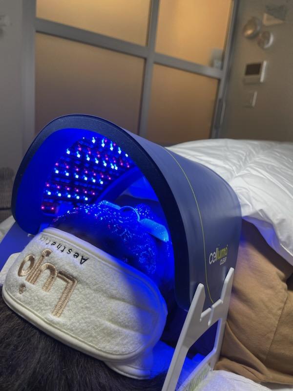 Client at Lujo Aesthetics facial spa, Plymouth, MN, receiving blue light LED therapy.